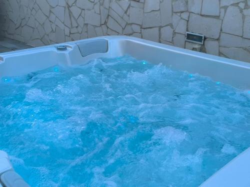 a tub filled with blue water in a bathroom at Villa S in Vir