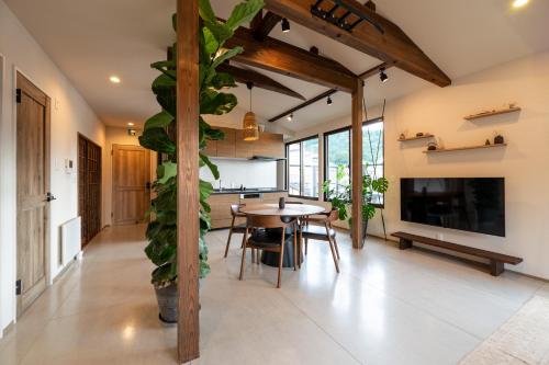 a living room with a table and a large plant at Oguma House in Nozawa Onsen