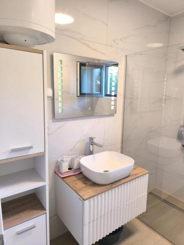 a white bathroom with a sink and a shower at Villa S in Vir