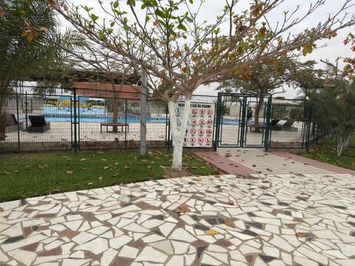 a tree in a park next to a playground at Cassoma Home Angola in Belas