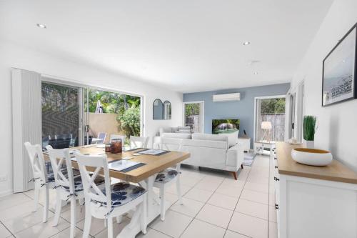 a kitchen and living room with a table and chairs at Private Poolside Villa in Urangan