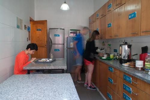 a group of people standing in a kitchen at Hostal Forestal in Santiago