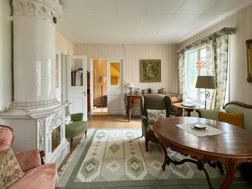 a living room with a table and a fireplace at Historic Vicarage By The Lake In Dalskog in Dalskog