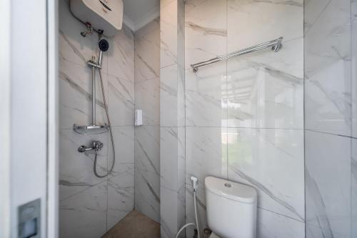 a white bathroom with a shower and a toilet at Cove Wyneth in Rawabokor Dua