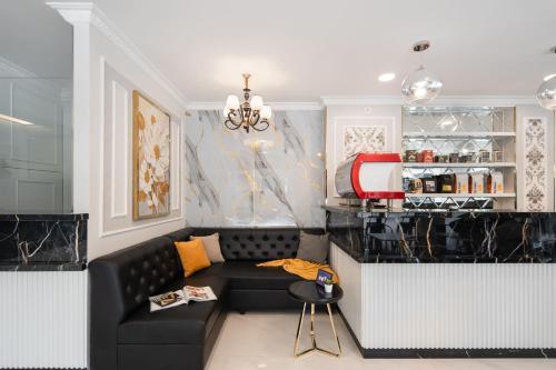 a living room with a black couch and a counter at Cove Wyneth in Rawabokor Dua