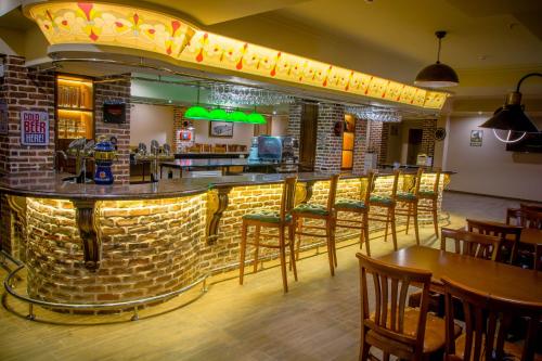 a bar in a restaurant with wooden tables and chairs at Bristol Central Park Hotel in Chişinău