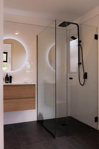 a bathroom with a shower and a sink at Lifebuoy Beach House Bicheno in Bicheno