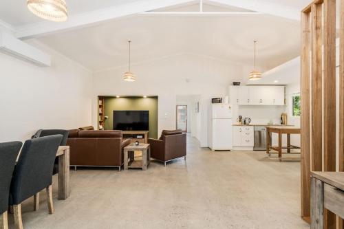 a living room with a couch and a table and a kitchen at Sol Sanctuary- Beachfront in Toogoom