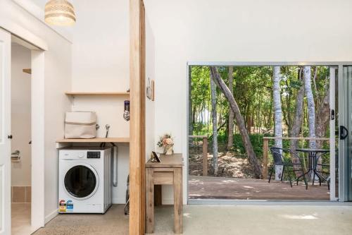 a laundry room with a washer and dryer and a patio at Sol Sanctuary- Beachfront in Toogoom