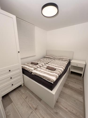 Dormitorio blanco con cama y lámpara en Hiška pod hrastom, G110 Podčetrtek, Aqualuna, Olimia, en Podčetrtek