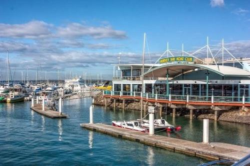 a boat is docked at a marina with a pier at Coastal Family Escape in Urangan