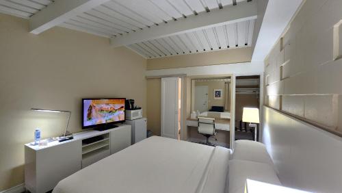 a white room with a bed and a television at Palo Alto Lodge in Palo Alto