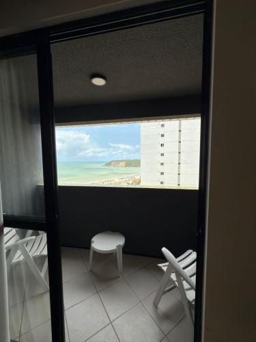 Cette chambre dispose d'une fenêtre offrant une vue sur la plage. dans l'établissement Quality suites natal apto 1009, à Natal
