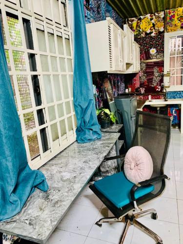 a room with a blue chair and a counter with a table at Chill Door Homestay in Ấp Long Ðại