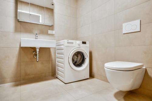 a bathroom with a washing machine and a sink at High Rise Balcony I Roof Top Pool I Close to Metro in Vienna