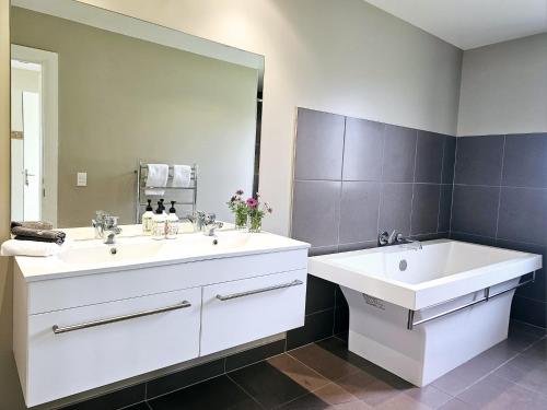 a bathroom with two sinks and a large mirror at Pohara Heights Executive Holiday Home in Pohara