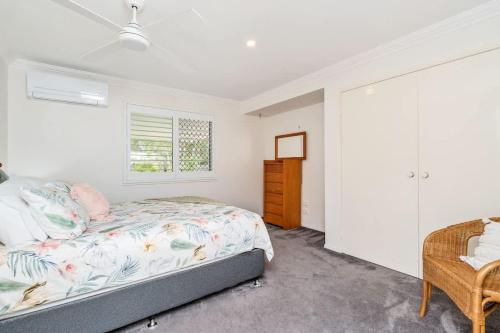 a bedroom with a bed and a window at Private Family Retreat - Pool Spa Tennis firepit in Hervey Bay