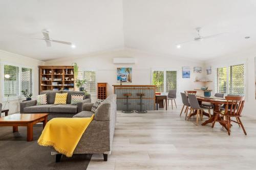 a living room with a couch and a table at Private Family Retreat - Pool Spa Tennis firepit in Hervey Bay