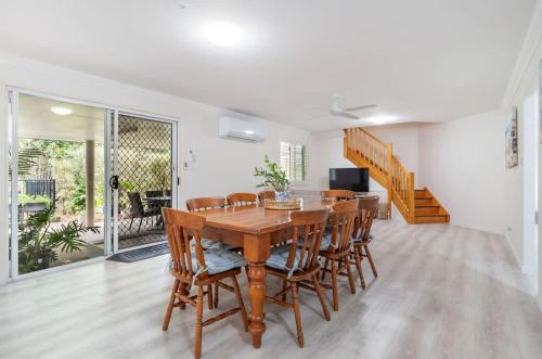 a dining room with a wooden table and chairs at Private Family Retreat - Pool Spa Tennis firepit in Hervey Bay