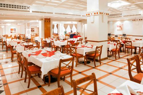 a dining room with white tables and wooden chairs at Landmark Hotel in Dubai