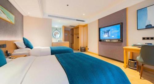 a bedroom with a large bed and a flat screen tv at Xian Katie Eastman Hotel in Xi'an