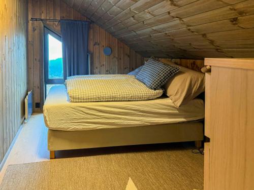 a bed in a small room with a window at Modern Cabin With Mountain Views In Rauland in Torvetjørn