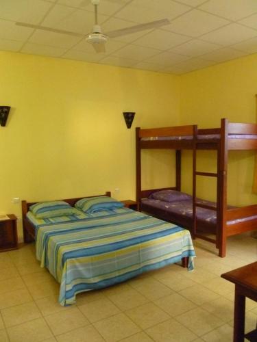 a bedroom with a bed and two bunk beds at Residence Kathyly in Diego Suarez