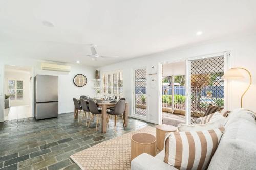a living room with a couch and a table with chairs at Whitesands Family Beachhouse in Urangan