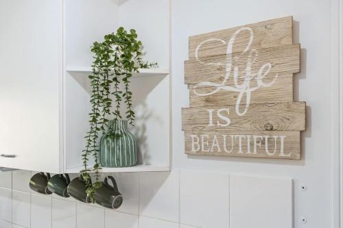 a kitchen with a sign that says life is beautiful at Whitesands Family Beachhouse in Urangan