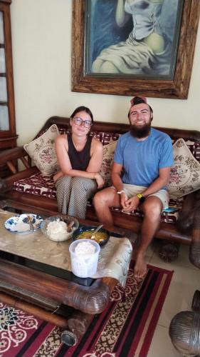 a man and a woman sitting on a couch at Misran Homestay in Triwung