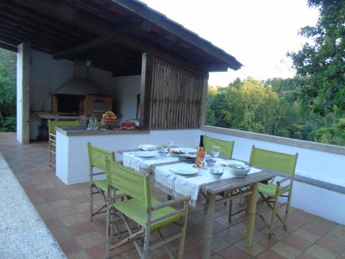 a table and chairs on a patio with a kitchen at Quinta da Chouza Agroturismo e Enoturismo in Celorico de Basto