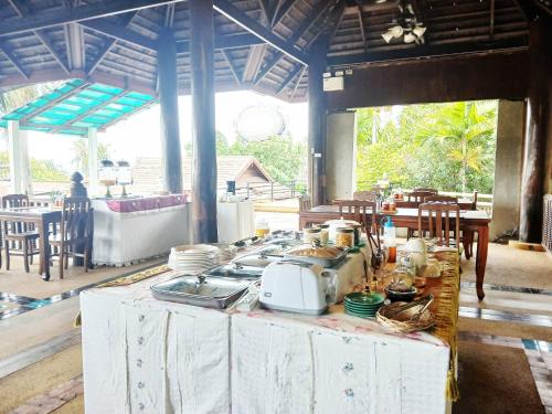 a kitchen with a table with a stove and dishes at Samui Wooden Hill Resort in Lamai