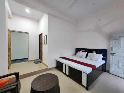 a bedroom with a bed and a chair in it at Thakur Guest House in Jawāla Mukhi Road