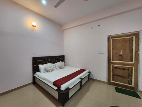 a bedroom with a bed in a room with a window at Thakur Guest House in Jawāla Mukhi Road