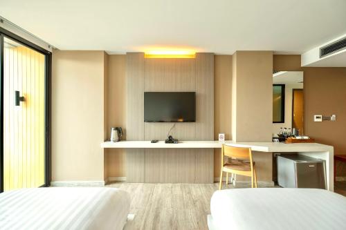 a hotel room with two beds and a television at The Zense Boutique Hotel in Phitsanulok