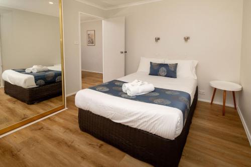 a bedroom with two beds and a mirror at BIG4 Swan Hill in Swan Hill