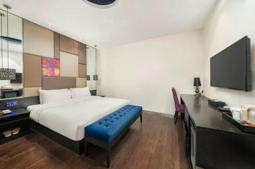 a bedroom with a bed and a desk and a tv at Juyue hotel Hongqiao Airport in Shanghai