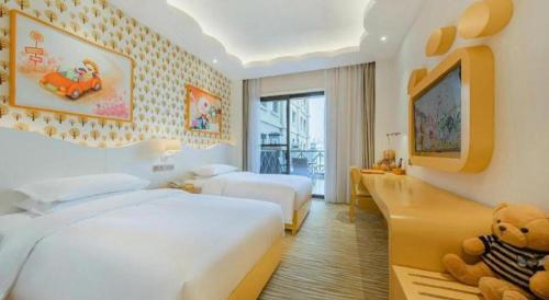 a hotel room with two beds and a teddy bear at Deefly Yinrun Town Hotel in Deqing