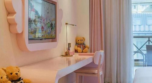 two teddy bears sitting on a table in a room at Deefly Yinrun Town Hotel in Deqing