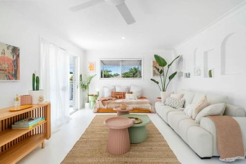 a white living room with a couch and a table at The Springs Villa 1 in Urangan