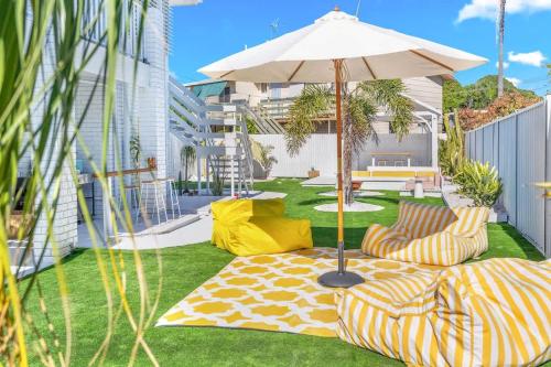 a patio with two chairs and an umbrella at The Springs Villa 1 in Urangan