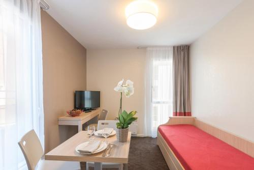 a room with a bed and a table with a red rug at Appart'City Classic Nantes Quais de Loire in Nantes