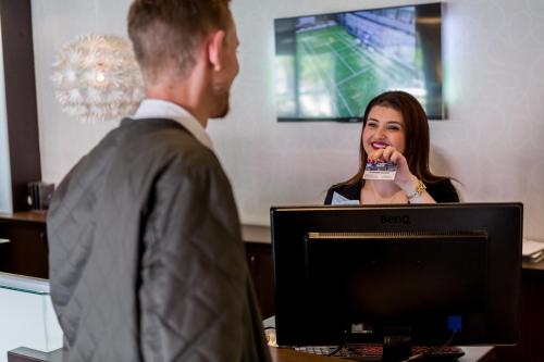 a man interviewing a woman in front of a computer at ProfilHotels Mercur in Copenhagen