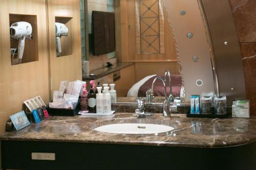a bathroom counter with a sink and a mirror at HOTEL & SPA J-MEX Shinjuku Kabukicho (Adult Only) in Tokyo