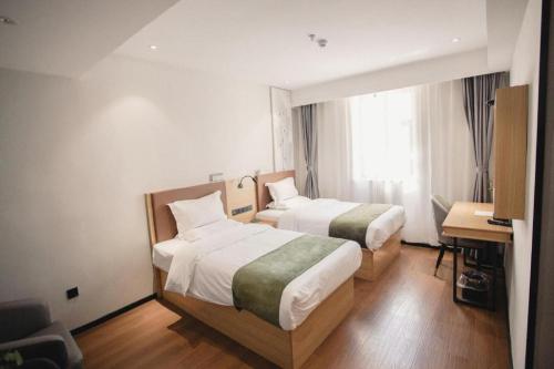 a hotel room with two beds and a desk at GreenTree Inn Express Datong High-Speed Railway Station Old City Wall in Datong