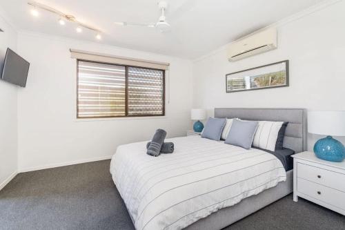 a bedroom with a large bed and a window at Coastal Cottage in Urangan