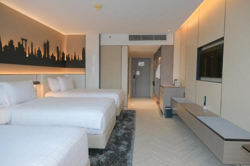a hotel room with two beds and a flat screen tv at Pathumwan Princess Hotel - SHA Extra Plus Certified in Bangkok