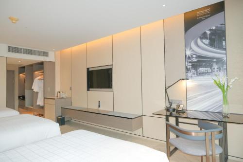 a bedroom with a bed and a desk and a tv at Pathumwan Princess Hotel - SHA Extra Plus Certified in Bangkok