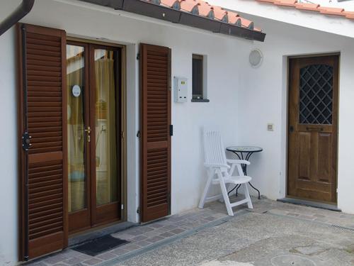 a white house with wooden doors and a table at Al Cortile Tranquillo in Cascina
