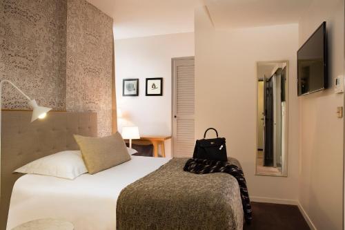 a hotel room with a bed and a desk at Hotel De Nemours Rennes in Rennes